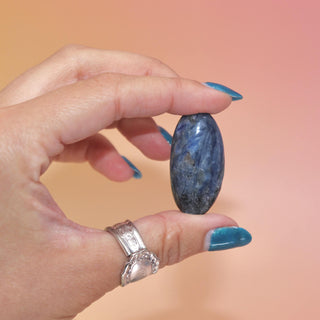 Hand holding a polished Blue Kyanite tumble