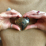 pyrite crystal heart in hands 
