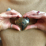 pyrite crystal heart in hands 