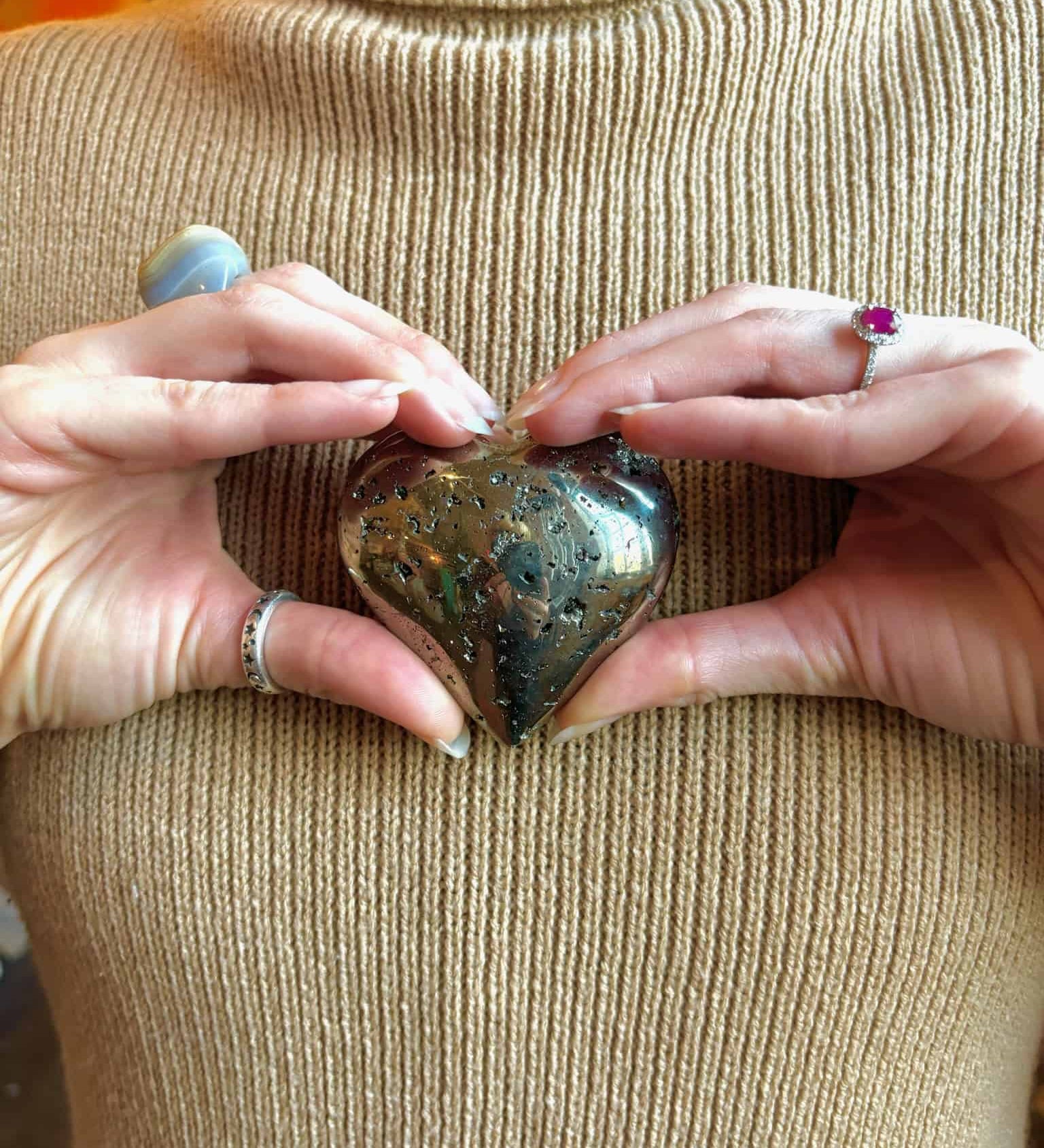 pyrite crystal heart in hands 