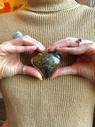 pyrite crystal heart in hands 