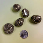Pyrite Crystal Tumbled Stone on greenish background with quarter for size reference