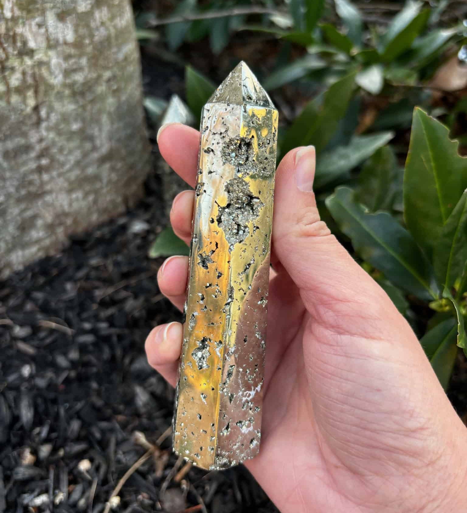 Pyrite Crystal Obelisk Tower in front of a mulch bed