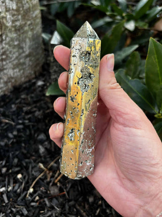 Pyrite Crystal Tower in hand over mulch