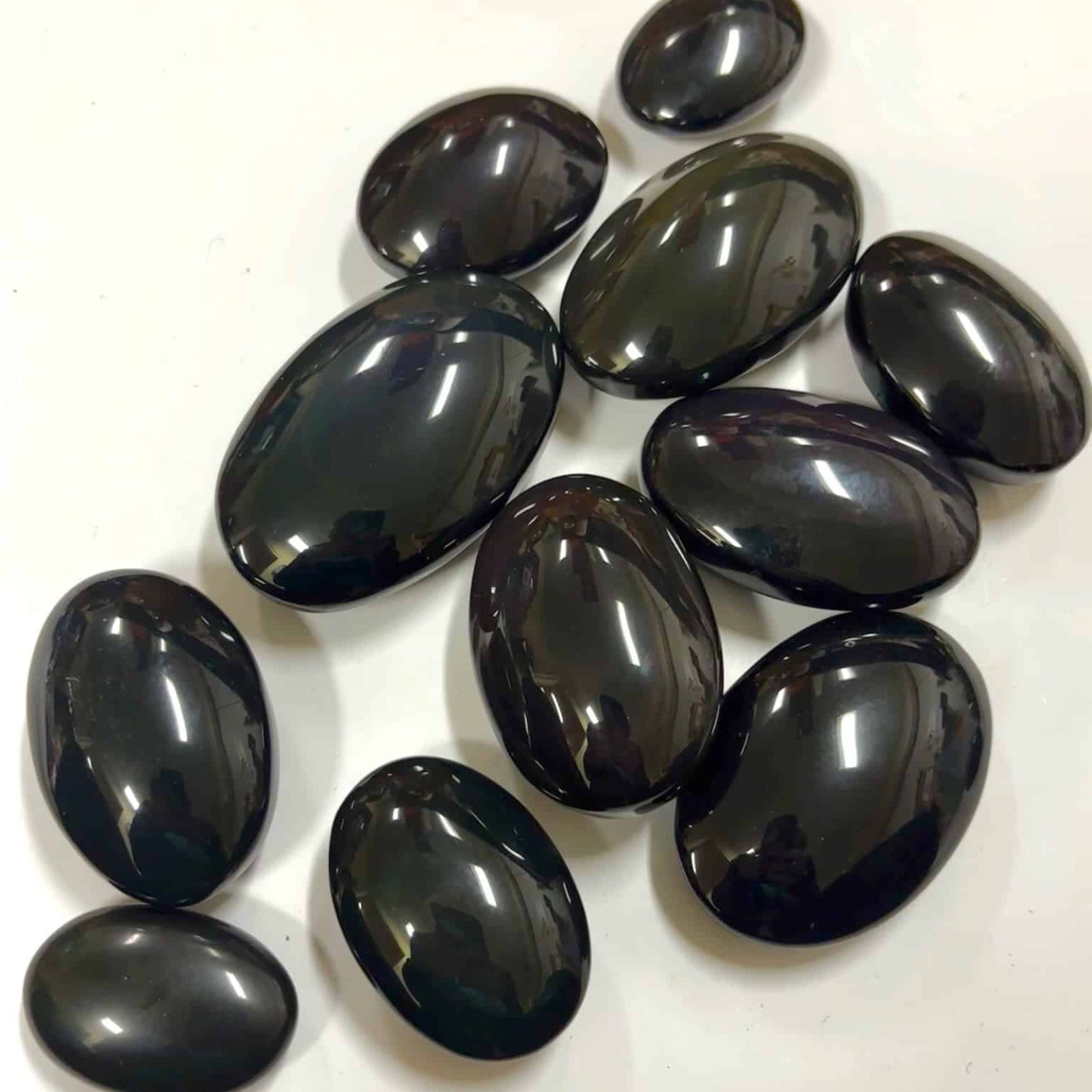 Glossy rainbow obsidian crystals showcasing deep green and purple iridescence