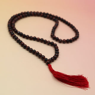 Red Tigers Eye 108 Mala Necklace on pink and orange background