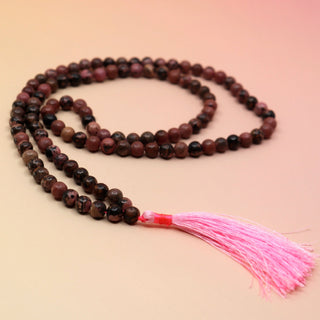 Rhodonite 108 Mala Necklace on pink and orange background