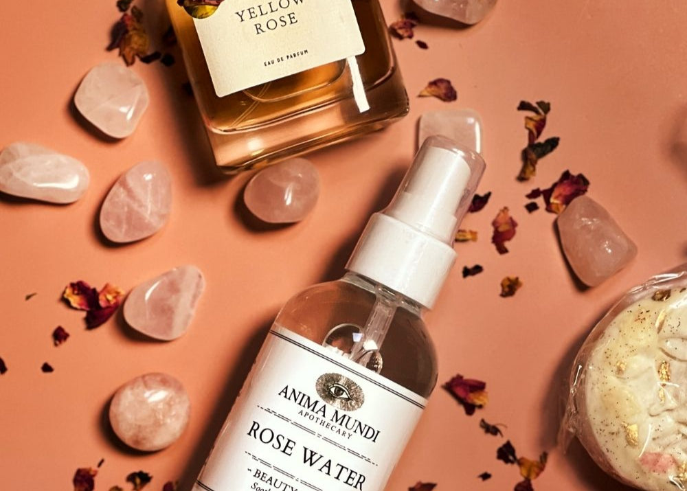 Cosmetic products including a bottle of rose water, a jar of cream, and a bottle of perfume on a peach-colored background.