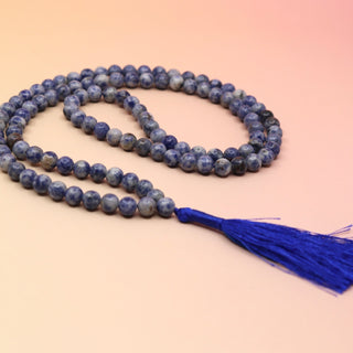 Sodalite 108 Mala Necklace on pink and orange background