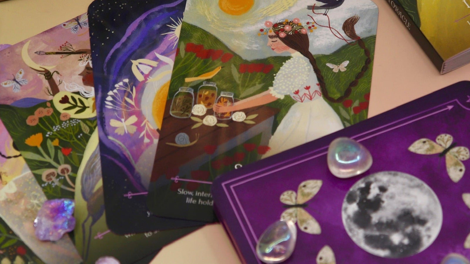 The cards of the Seasons of the Witch - Litha Oracle Card Deck with crystals around them.