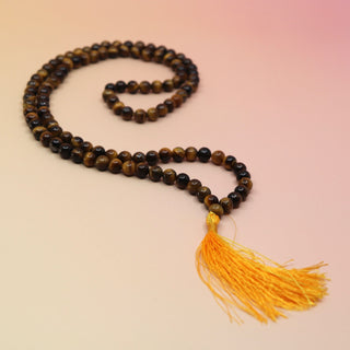 Tigers Eye 108 Mala Necklace on pink and orange background