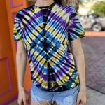 model wearing diamond tie dye t shirt in front of orange and pink building