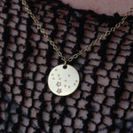 Someone wearing the Virgo 14k Gold Dipped Nickel-Free Zodiac Necklace with a black net top.