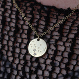 Someone wearing the Virgo 14k Gold Dipped Nickel-Free Zodiac Necklace with a black net top.