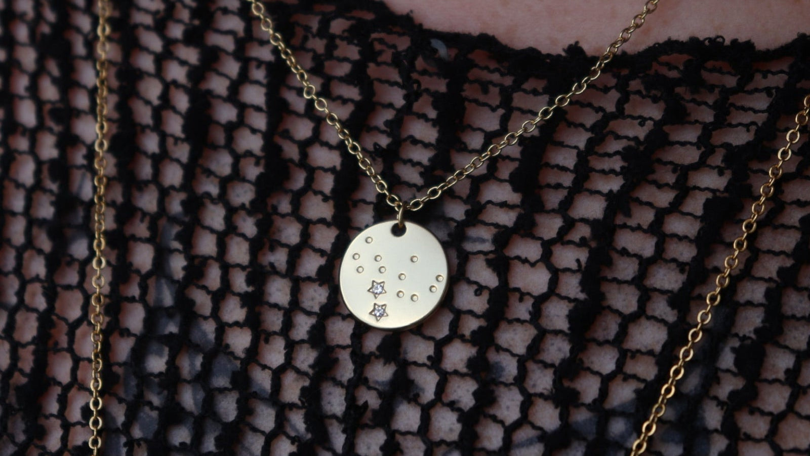 Someone wearing the Virgo 14k Gold Dipped Nickel-Free Zodiac Necklace with a black net top.