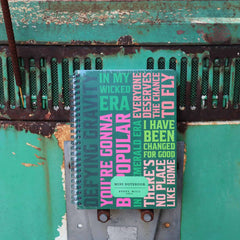 Wicked Book with colorful text on a rusty metal surface