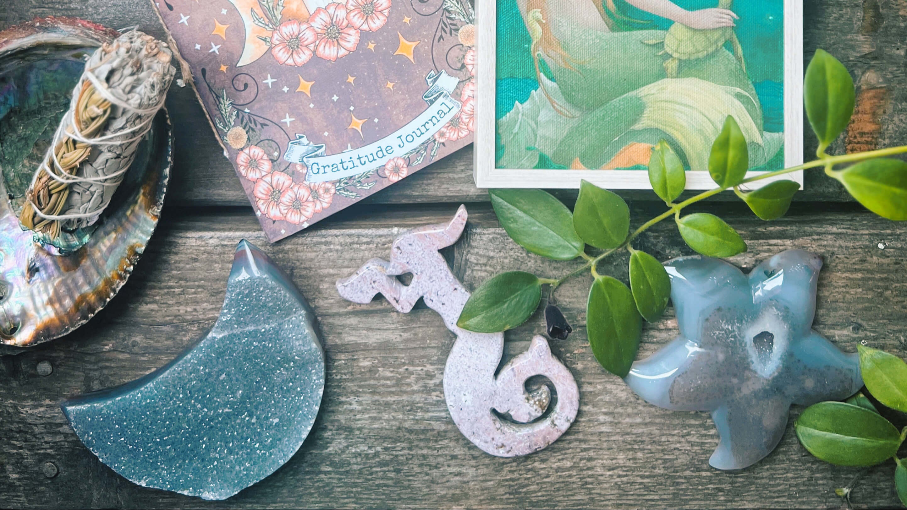 Two tarot cards on a wooden surface with greenery and decorative items.