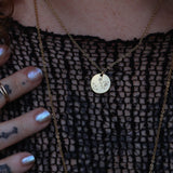Someone wearing the Sagittarius 14k Gold Dipped Nickel-Free Zodiac Necklace with a black net top.
