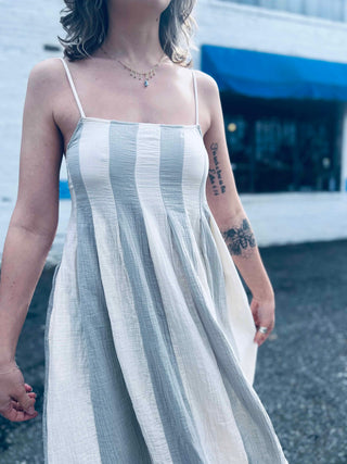 lightweight babydoll midi dress with spaghetti straps in front of shopping center 