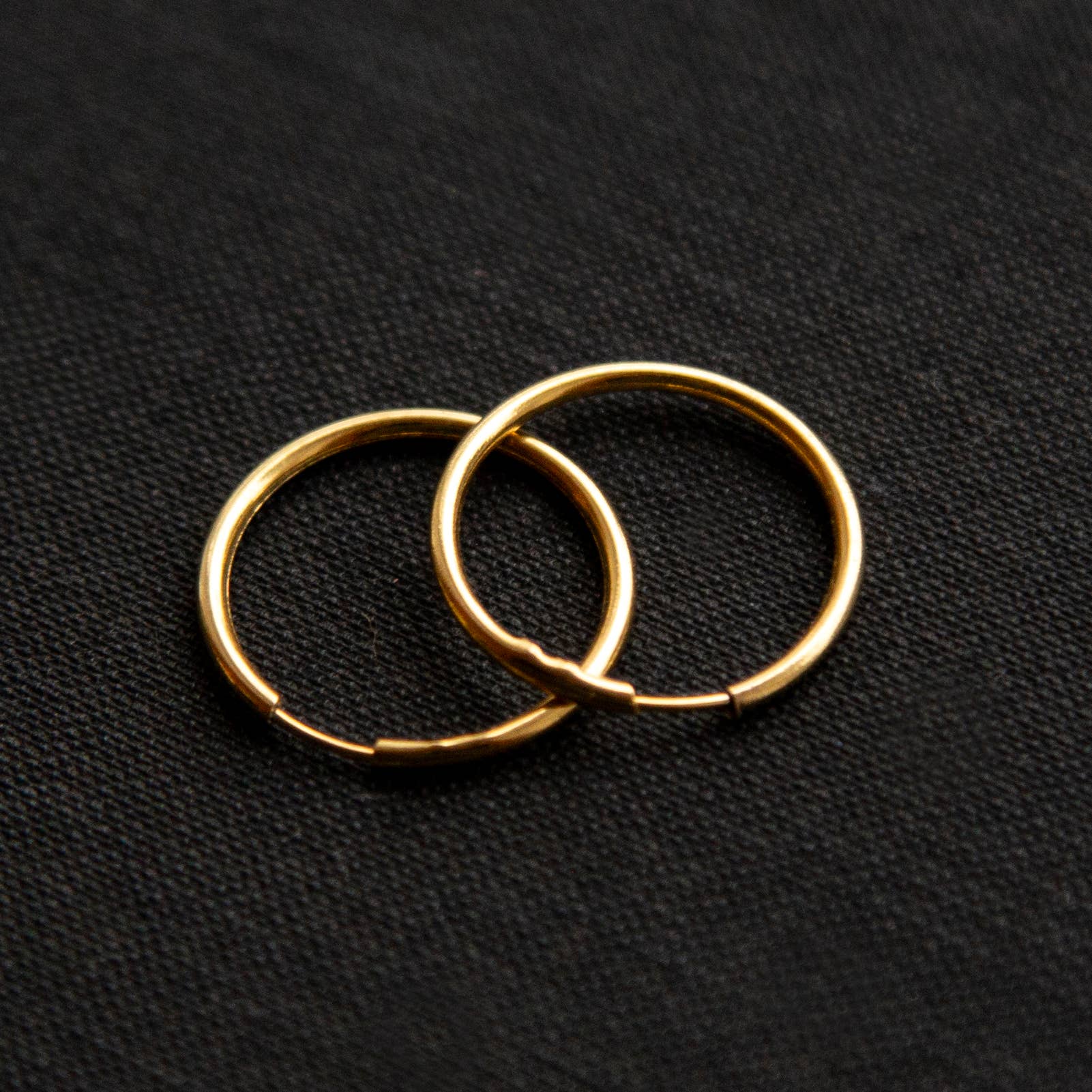 The gold Vintage Endless Hoops Earrings on a black background