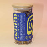 Egyptian Blue Lotus Flower Tea with whole purple petals and golden stamens spilling from jar.