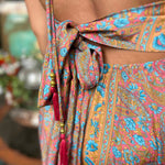 Model posing in silk boho maxi dress with bow tie back