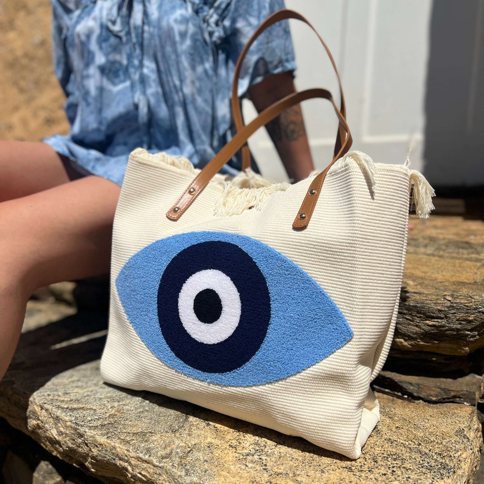 Close-up of blue evil eye embroidered design on boho tote bag
