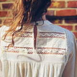 back view of boho chic mock neck top with keyhole closure in natural hue
