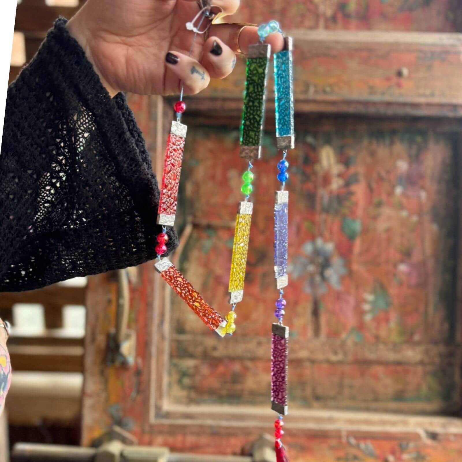 Colorful prism sun catcher with stained glass panels and beads, decorative window hanging that reflects rainbow light.