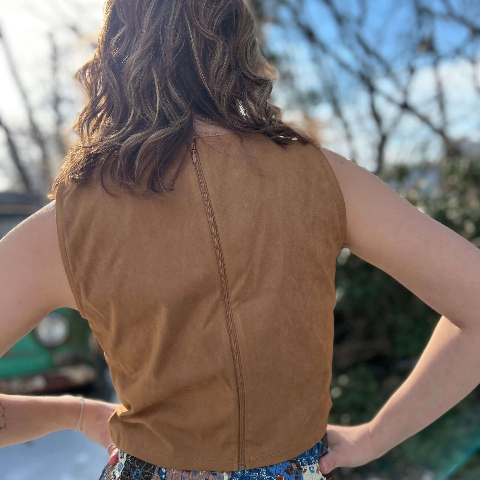 Back view of brown faux suede fringe crop top with zipper closure