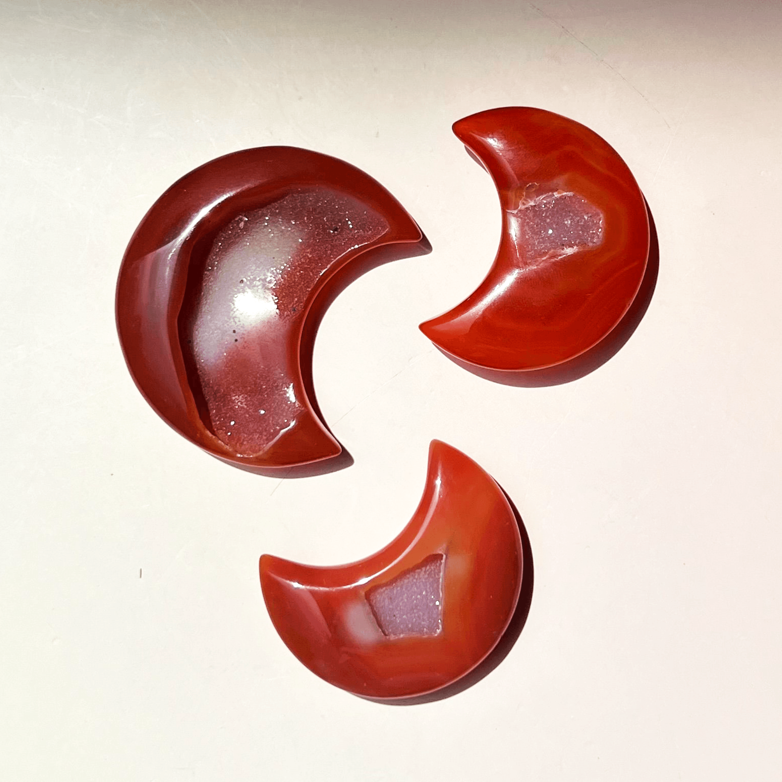 Carnelian crystal crescent moons in red and orange tones sized 1.9 to 2.5 inches with natural variations