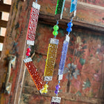 Boho rainbow window sun catcher made with stained glass panels and crystal beads, light-catching home decor accent.