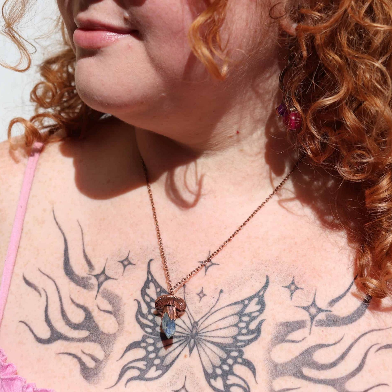 turquoise and amethyst necklace on girl with red curly hair and butterly tattoo