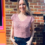 close up of a lightweight crochet knit detailing on a cotton v-neck cap sleeve top standing in front of the boho depot retail store 