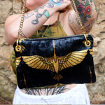 A woman holding the Black and Gold Heron Chain Strap Velvet Crossbody Bag.