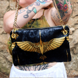 A woman holding the Black and Gold Heron Chain Strap Velvet Crossbody Bag.