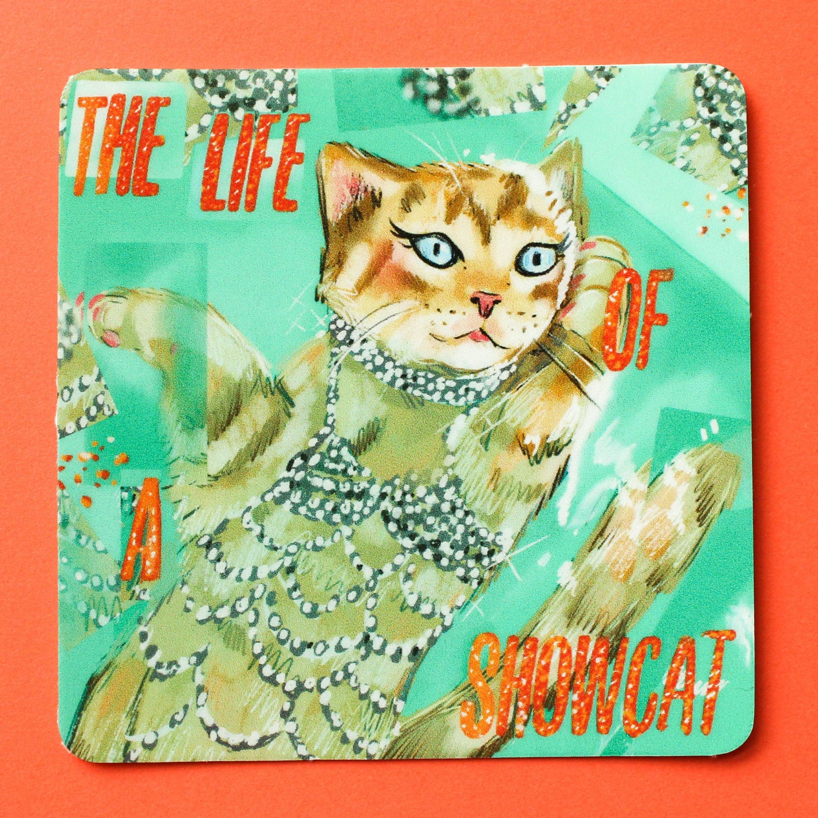 Sticker with a cat illustration and text 'The Life of a Showcat' on a colorful background