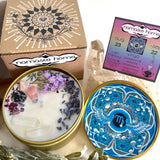 The Virgo Crystal Candle opened with the lid to the right of it. The packaging of the Virgo Crystal Candle is behind the candle next to a card.