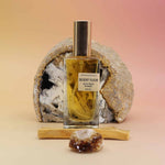 Perfume bottle labeled 'Desert Fleur' with a rock and wooden stick on a gradient background