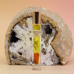 Desert Fleur Botanical Perfume rollerball – botanical fragrance with visible oil drop and geode backdrop