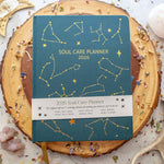 Soul Care Planner 2026 on a wooden surface with decorative elements