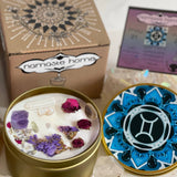 The Gemini Crystal Candle opened with the lid to the right of it. The packaging of the Gemini Crystal Candle is behind the candle next to a card