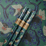 The Nouveau Twilight Butterflies Matte Fine Wrapping Paper laid out with three rolls on top.