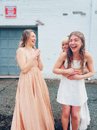 cute boho dresses in front of white brick