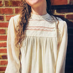 close up of intricate lace accents on mock neck boho top