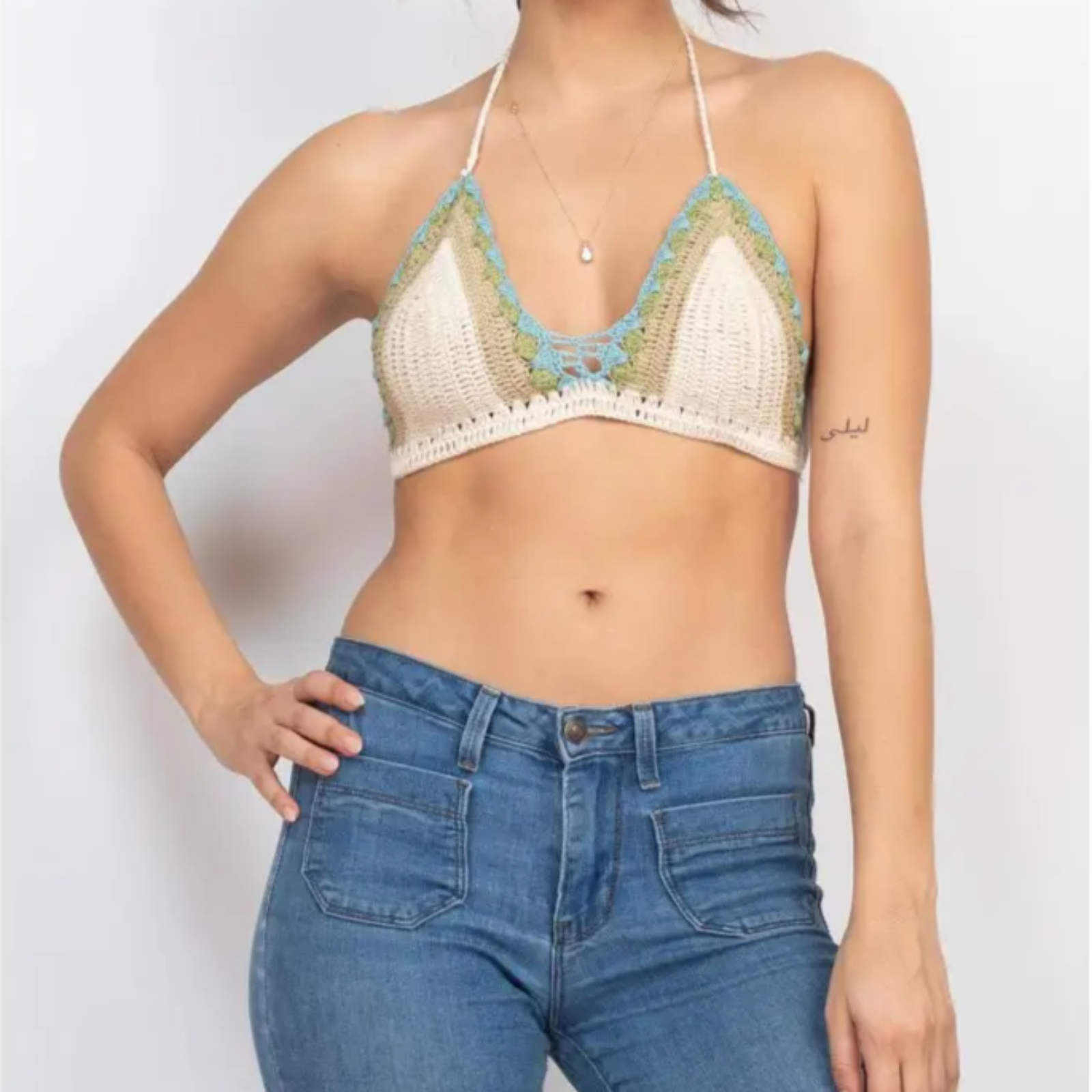 A woman wearing the off white Festive Crochet Top: One Size with jeans.