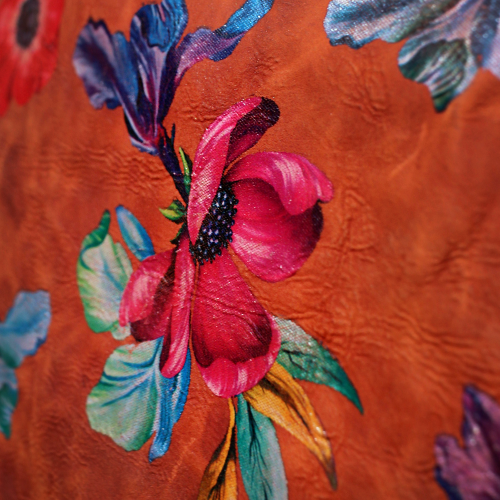 An up close image of the Orange Floral Print Italian Leather Crossbody Bag showing off its design.