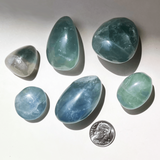 Close up of polished blue green fluorite crystal showing natural patterns and clarity