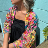 Woman wearing Frida Kahlo kimono robe seated at picnic table