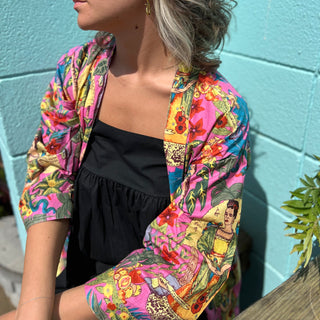 Woman wearing Frida Kahlo kimono robe seated at picnic table